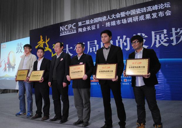 图3、pp电子游戏陶瓷荣获“天下建陶品牌20强”称呼，图为pp电子游戏品牌代表（左四）在接受颁奖情景